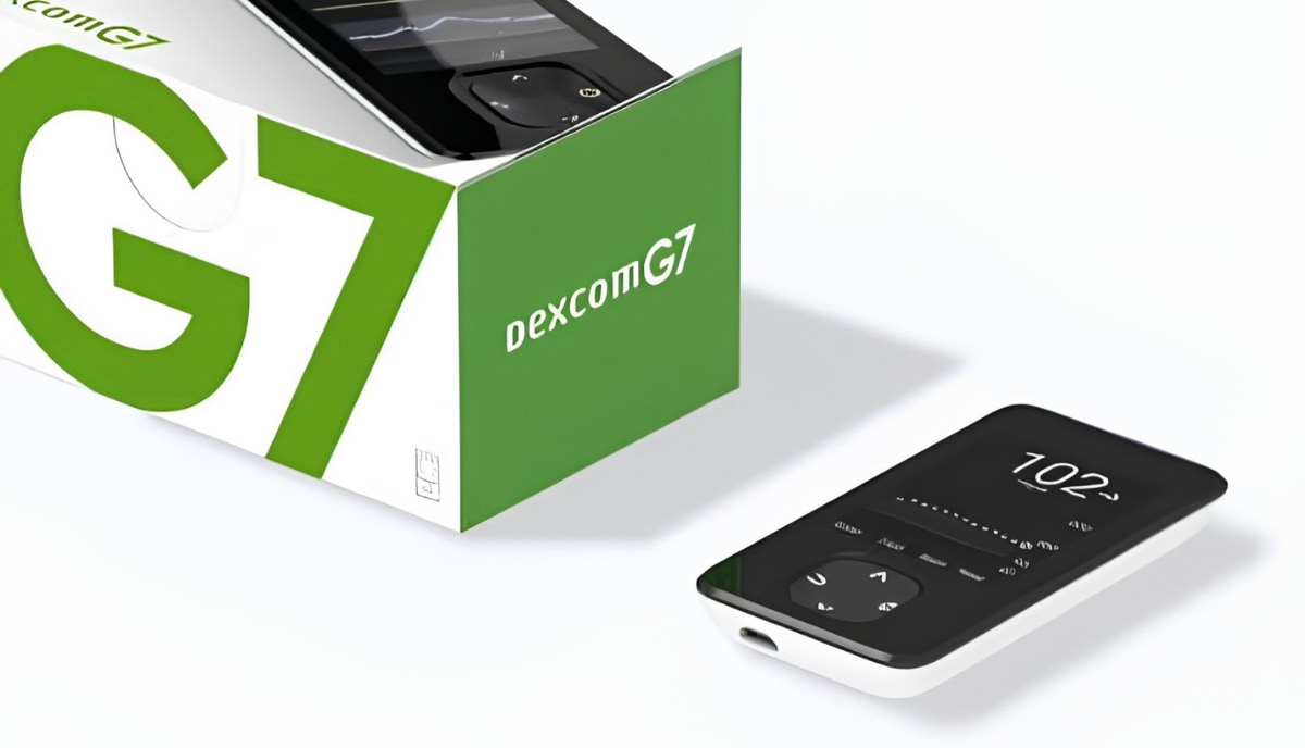Boîte de capteurs Dexcom G7 et lecteur dédié affichant une valeur de glucose, posés sur fond blanc.